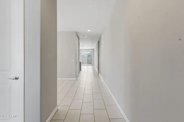 a view of a hallway with wooden floor and a bathroom