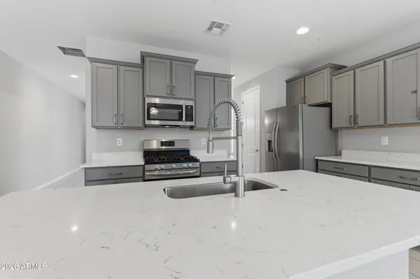 a kitchen with stainless steel appliances granite countertop a refrigerator stove microwave and sink