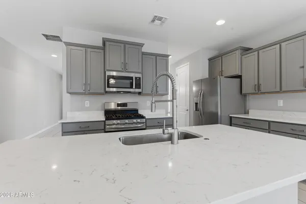 a kitchen with stainless steel appliances granite countertop a refrigerator stove microwave and sink