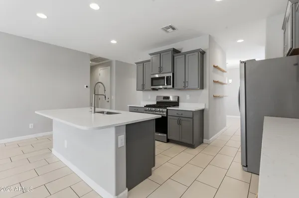 a kitchen with stainless steel appliances a sink a stove a refrigerator and cabinets