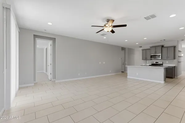 a view of kitchen with stainless steel appliances granite countertop white cabinets and window