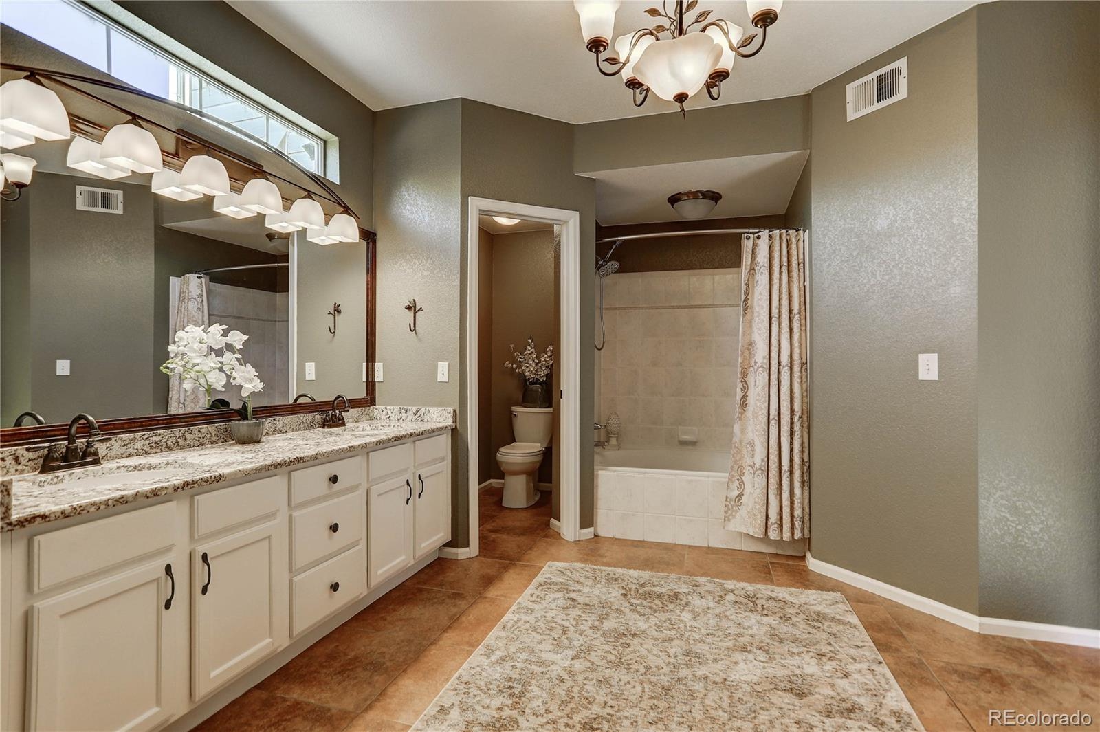 6830 Xavier Circle, Unit 3 Arvada, CO 80030 - Photo 18 of 28 a spacious bathroom with a granite countertop sink a mirror and a shower