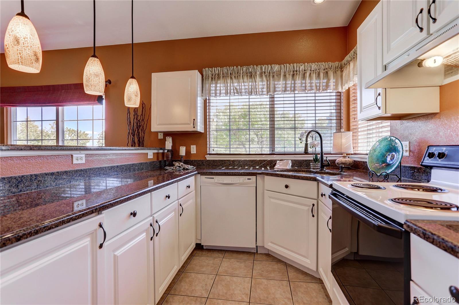 6830 Xavier Circle, Unit 3 Arvada, CO 80030 - Photo 8 of 28 a kitchen with granite countertop a sink window and cabinets