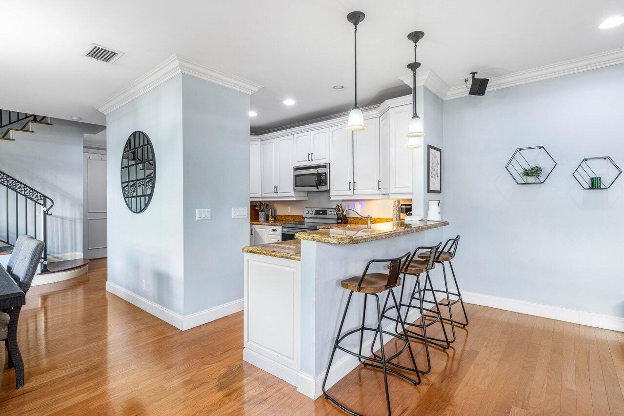 507 Southwest 17th Street Fort Lauderdale, FL 33315 - Photo 8 of 25 a kitchen with stainless steel appliances granite countertop a stove a refrigerator a kitchen island a sink and a wooden floor