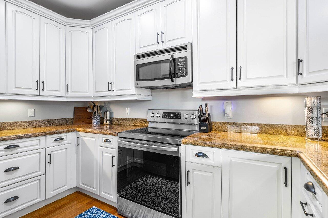 507 Southwest 17th Street Fort Lauderdale, FL 33315 - Photo 10 of 25 a kitchen with granite countertop white cabinets and stainless steel appliances