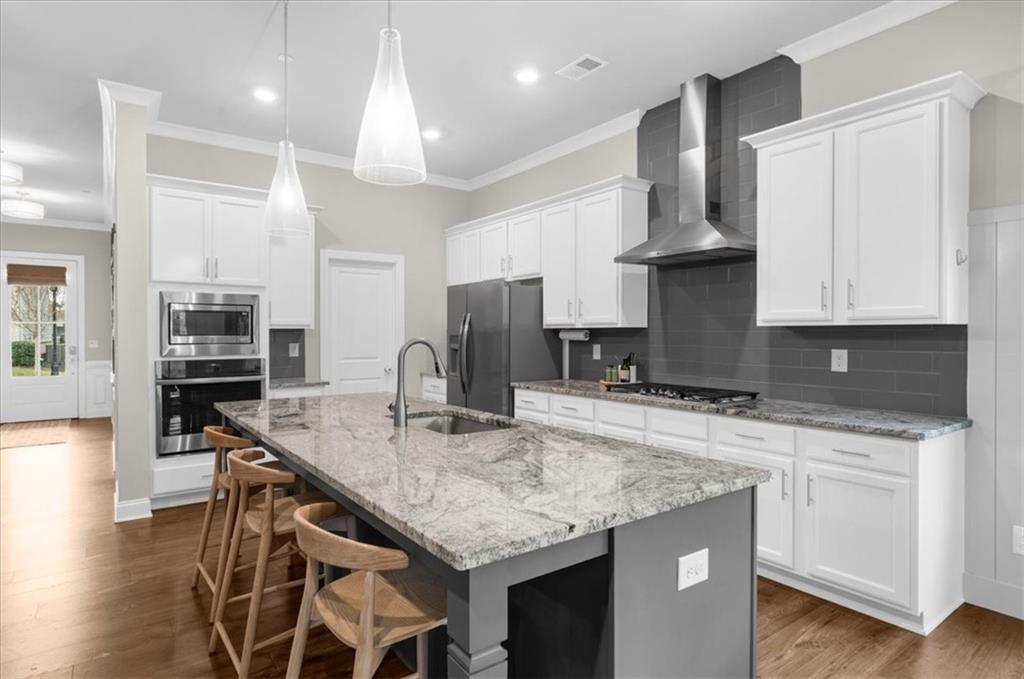 320 Senna Street Marietta, GA 30064 - Photo 16 of 53 a kitchen with granite countertop kitchen island stainless steel appliances a sink stove and cabinets