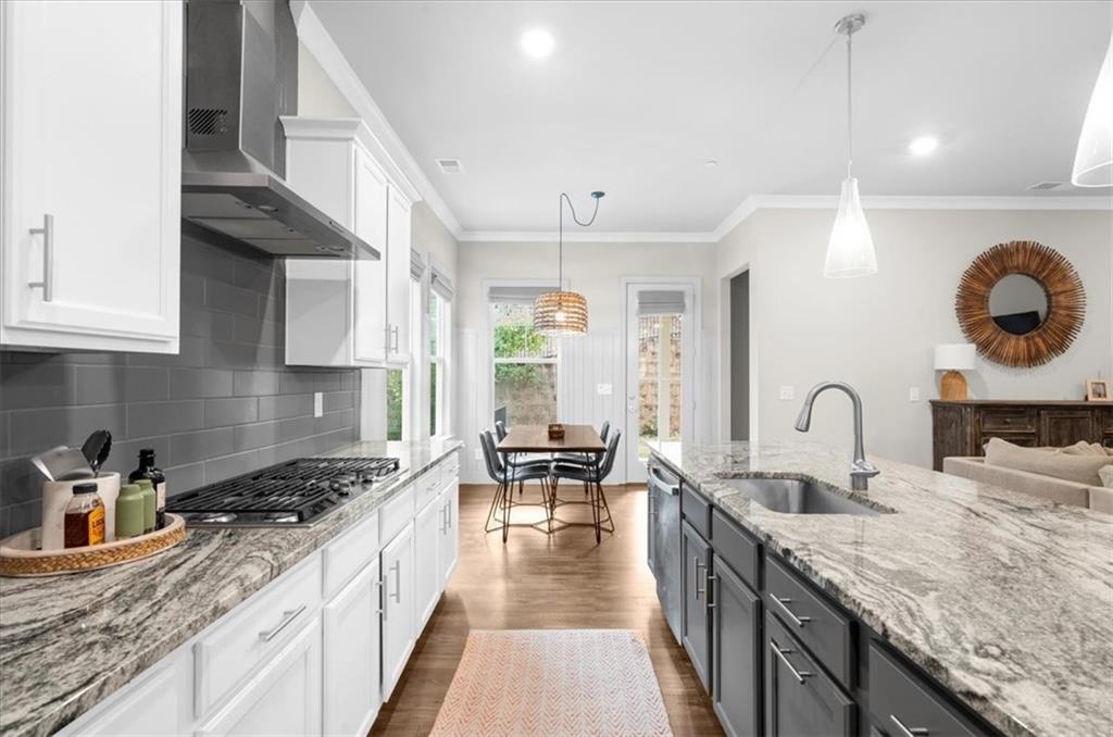 320 Senna Street Marietta, GA 30064 - Photo 21 of 53 a kitchen with granite countertop a stove a sink dishwasher a dining table and chairs with wooden floor