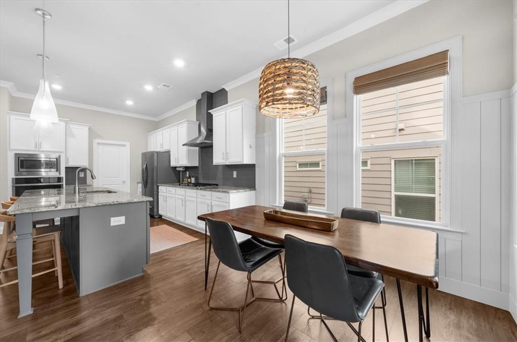 320 Senna Street Marietta, GA 30064 - Photo 23 of 53 a kitchen with stainless steel appliances granite countertop a stove top oven a refrigerator a sink dishwasher a dining table and chairs with wooden floor