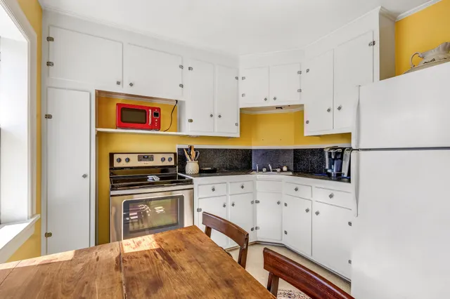 a kitchen with stainless steel appliances a stove a refrigerator white cabinets and a refrigerator