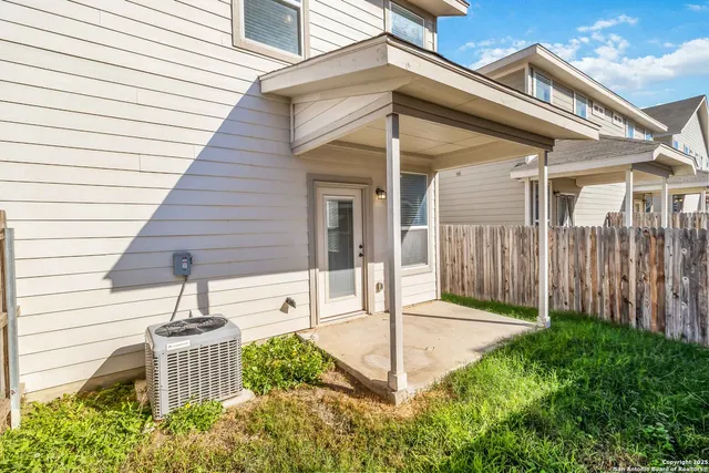 a view of swimming pool that has lawn chairs with plants and large trees