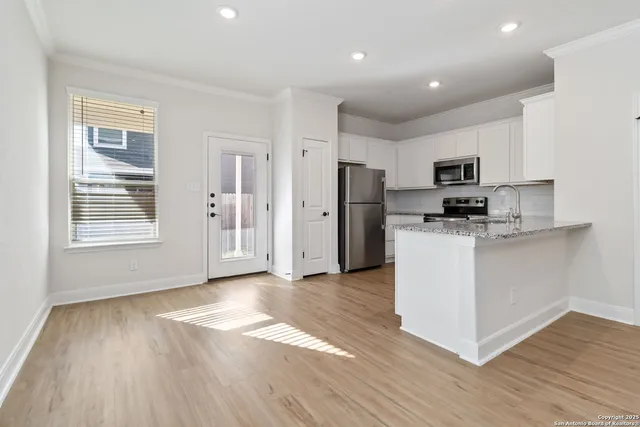 a kitchen with stainless steel appliances a refrigerator and a stove top oven