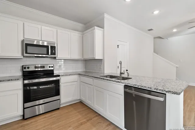 a kitchen with stainless steel appliances granite countertop a stove a microwave and a sink