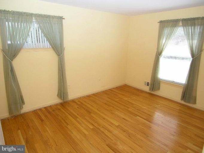 1204 Smith Village Road Silver Spring, MD 20904 - Photo 3 of 17 a bedroom with a bed and wooden floor