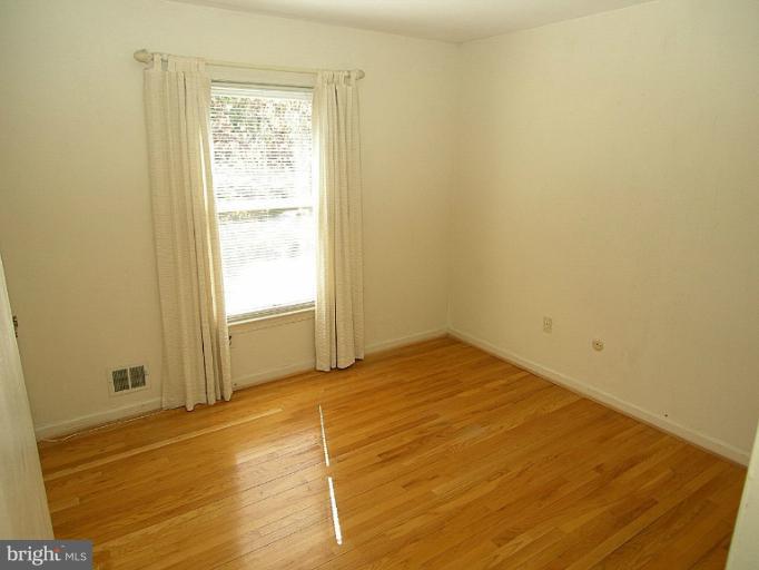 1204 Smith Village Road Silver Spring, MD 20904 - Photo 4 of 17 a view of empty room with wooden floor and fan
