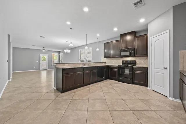 a large kitchen with stainless steel appliances granite countertop a large counter top and a stove top oven