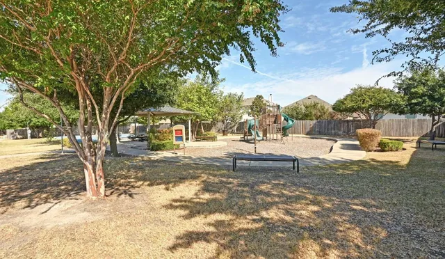 a front view of a house with garden and trees