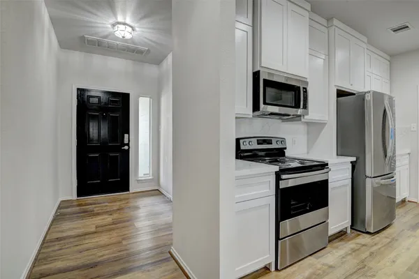 a view of kitchen and hall with wooden floor