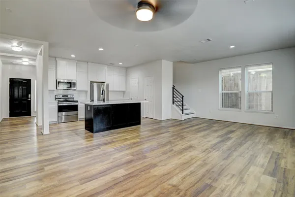 a kitchen with kitchen island a sink stainless steel appliances and cabinets