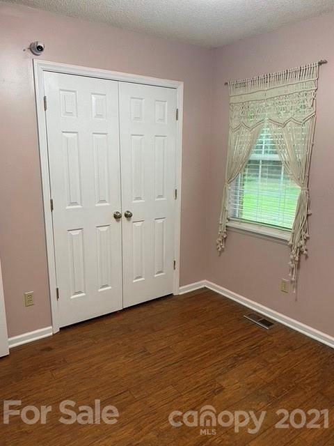 409 Chaney Road Monroe, NC 28110 - Photo 12 of 23 an empty room with wooden floor and windows