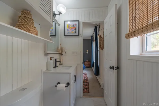 a bathroom with a sink and mirror with toilet