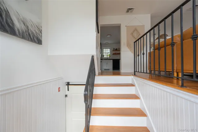 a view of staircase with white walls and a black door