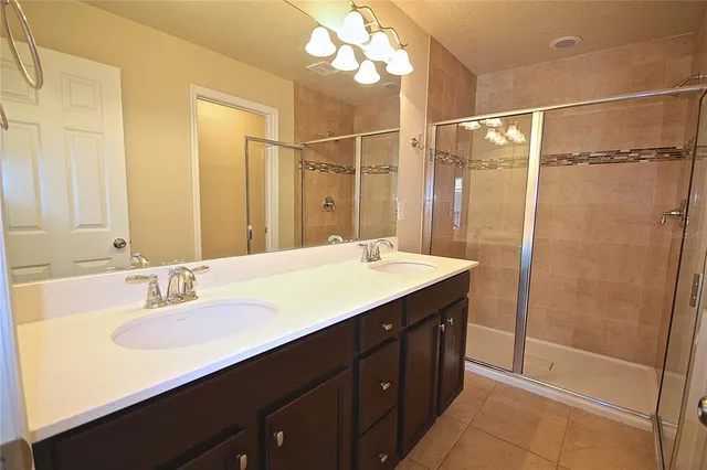 a bathroom with a double vanity sink mirror and shower