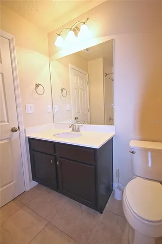 a bathroom with a sink vanity mirror and toilet