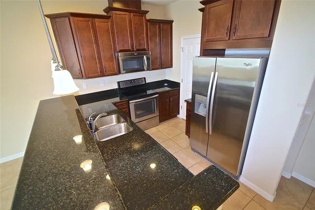 a kitchen with stainless steel appliances a refrigerator a stove a sink and a counter top space
