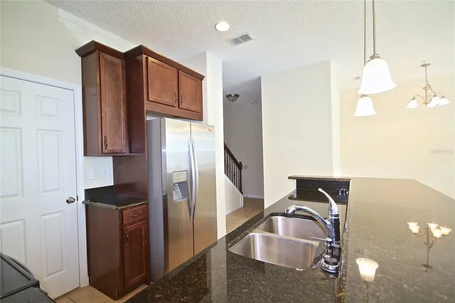 a kitchen with stainless steel appliances granite countertop a refrigerator and a sink