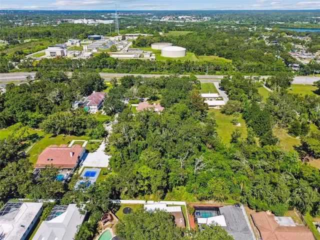 an aerial view of residential houses with outdoor space and trees