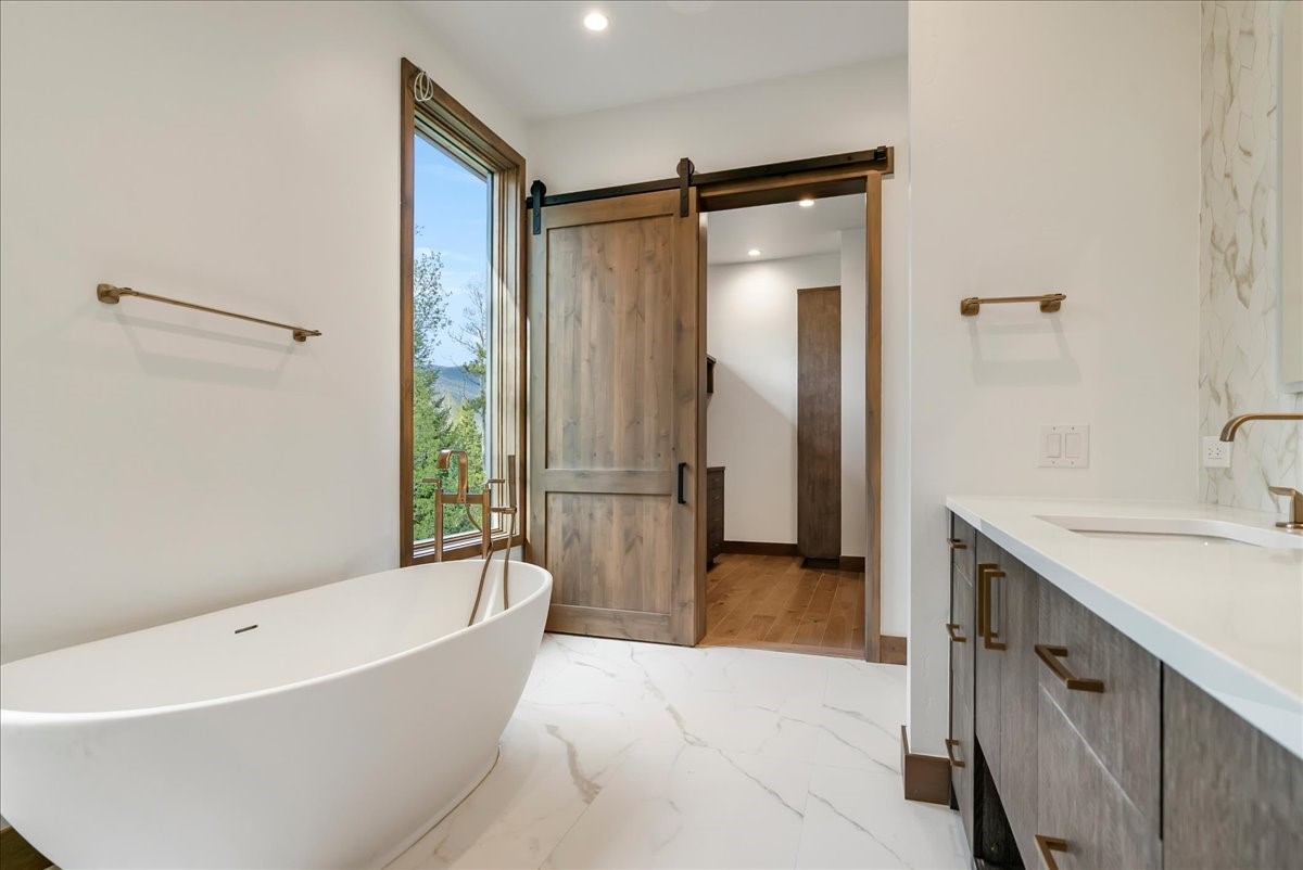 1615 Golden Eagle Road Silverthorne, CO 80498 - Photo 27 of 47 a bathroom with a tub a sink and a mirror