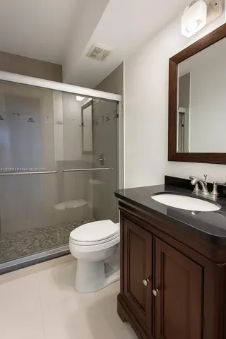 a bathroom with a granite countertop sink a toilet and a mirror