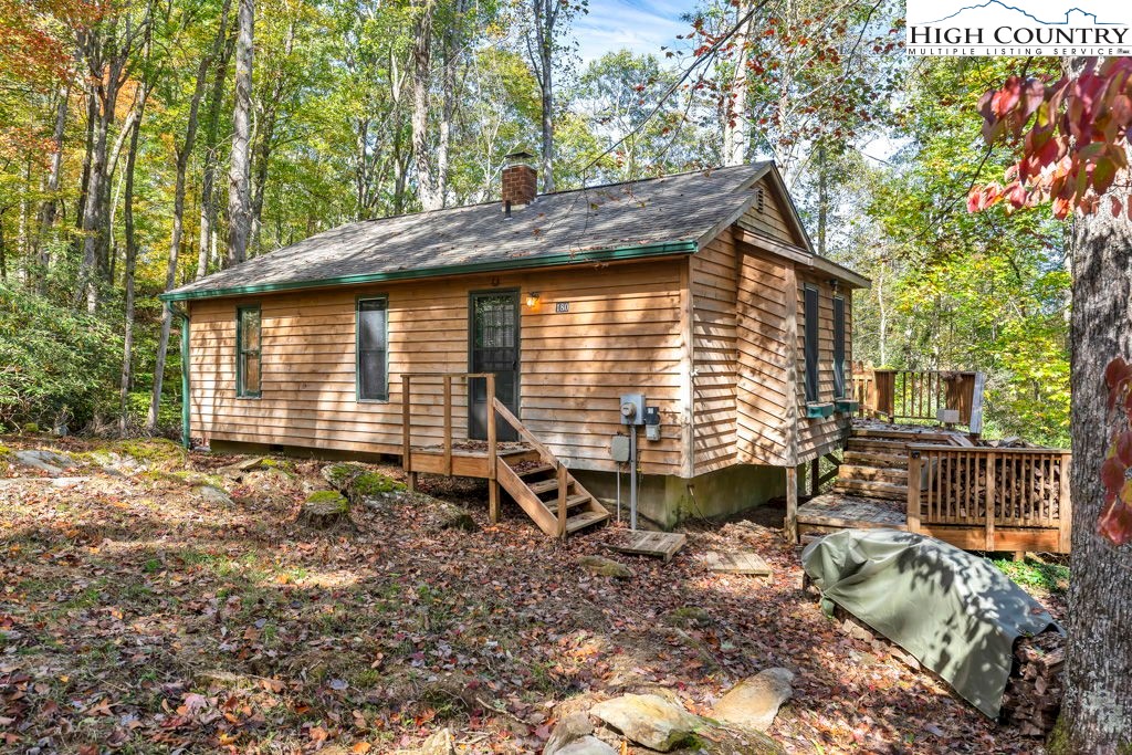 180 Wild Blackberry Hill Road Boone, NC 28607 - Photo 21 of 30 a backyard of a house with table and chairs
