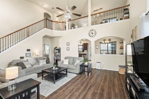 a living room with furniture a flat screen tv and a floor to ceiling window