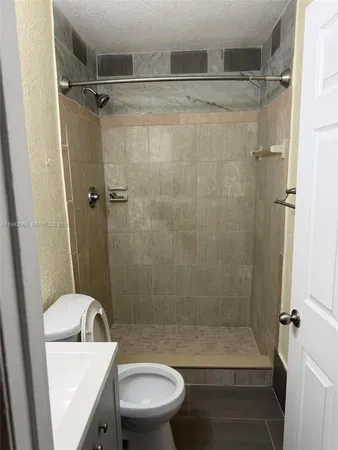 a bathroom with a shower a toilet and a sink