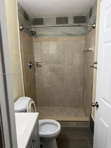 a bathroom with a shower a toilet and a sink
