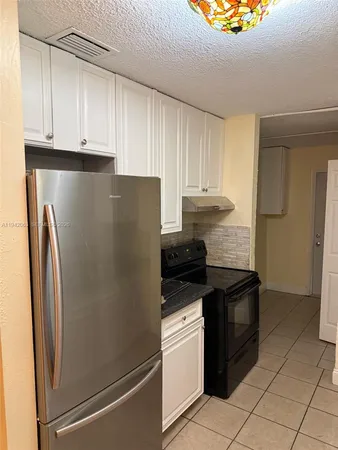 a kitchen with granite countertop a refrigerator and a stove