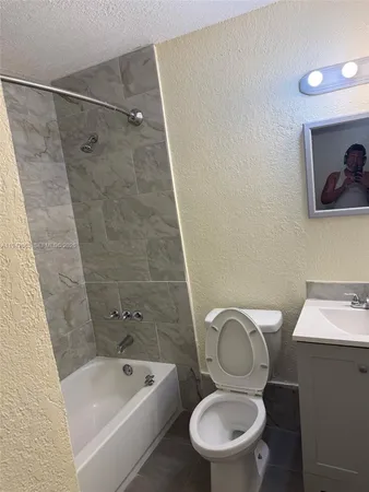 a bathroom with a toilet a sink and bathtub