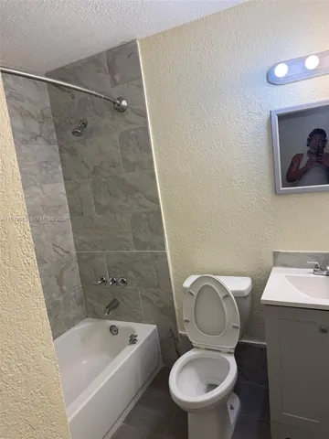a bathroom with a toilet a sink and bathtub