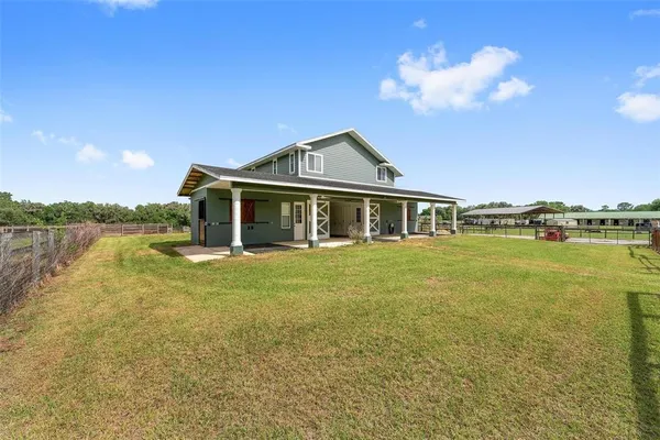 a front view of a house with a garden and lake view