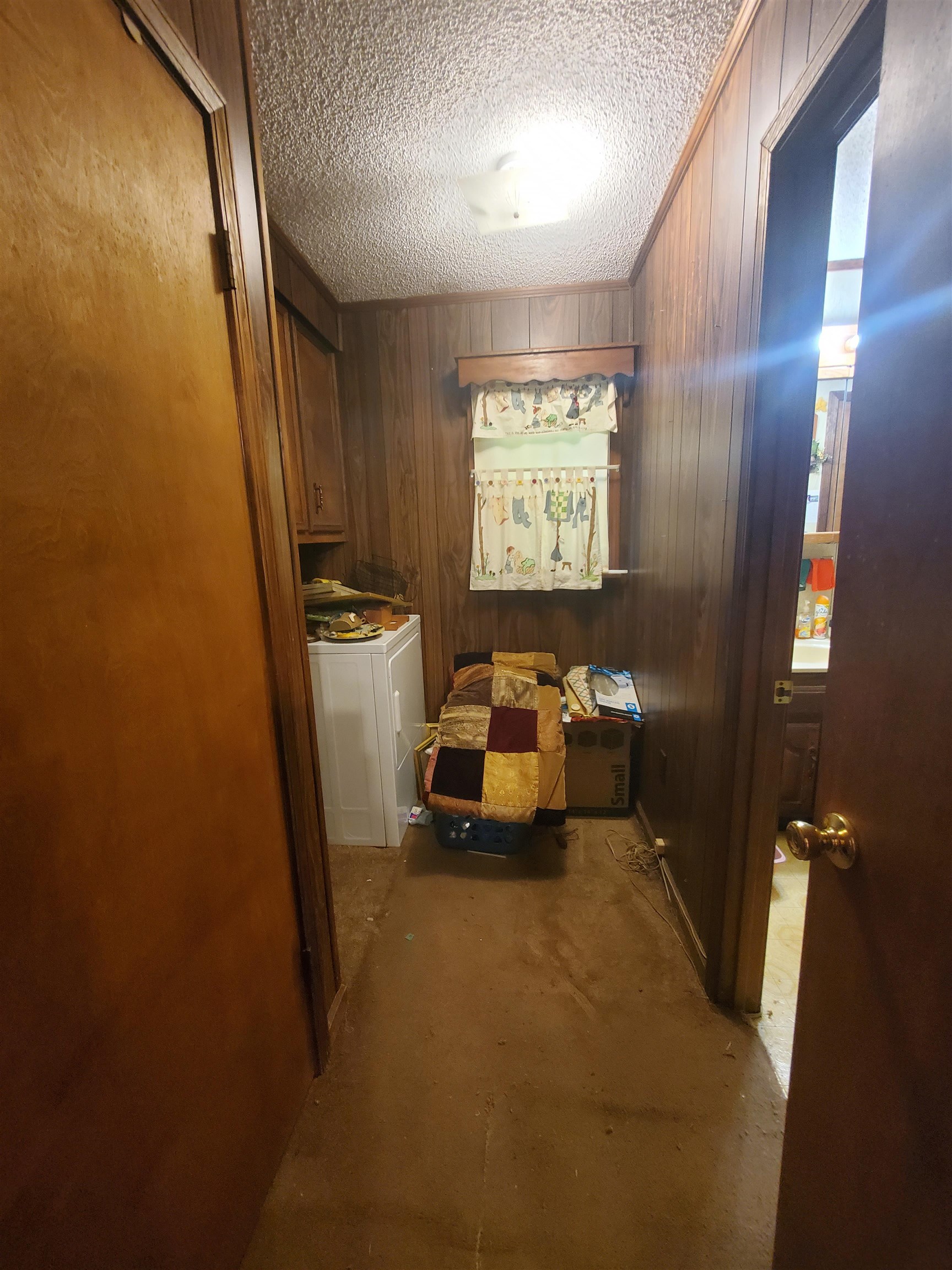 147 Rogers Street Sharon, TN 38255 - Photo 16 of 16 Compact utility area featuring wood paneling, a single window, and a built-in cabinet