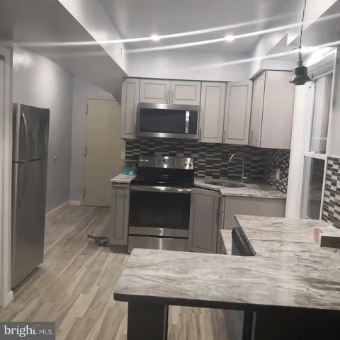 a kitchen with kitchen island a counter top a stove and a refrigerator