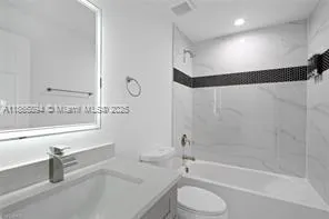 a bathroom with a bathtub shower sink vanity and toilet