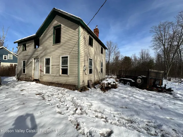 a view of a house with a yard and trees in the background