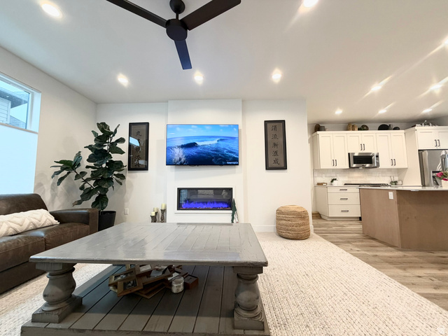 545 East 7215 South Midvale, UT 84047 - Photo 12 of 27 Living area with ceiling fan, a glass covered fireplace, light wood-type flooring, and recessed lighting