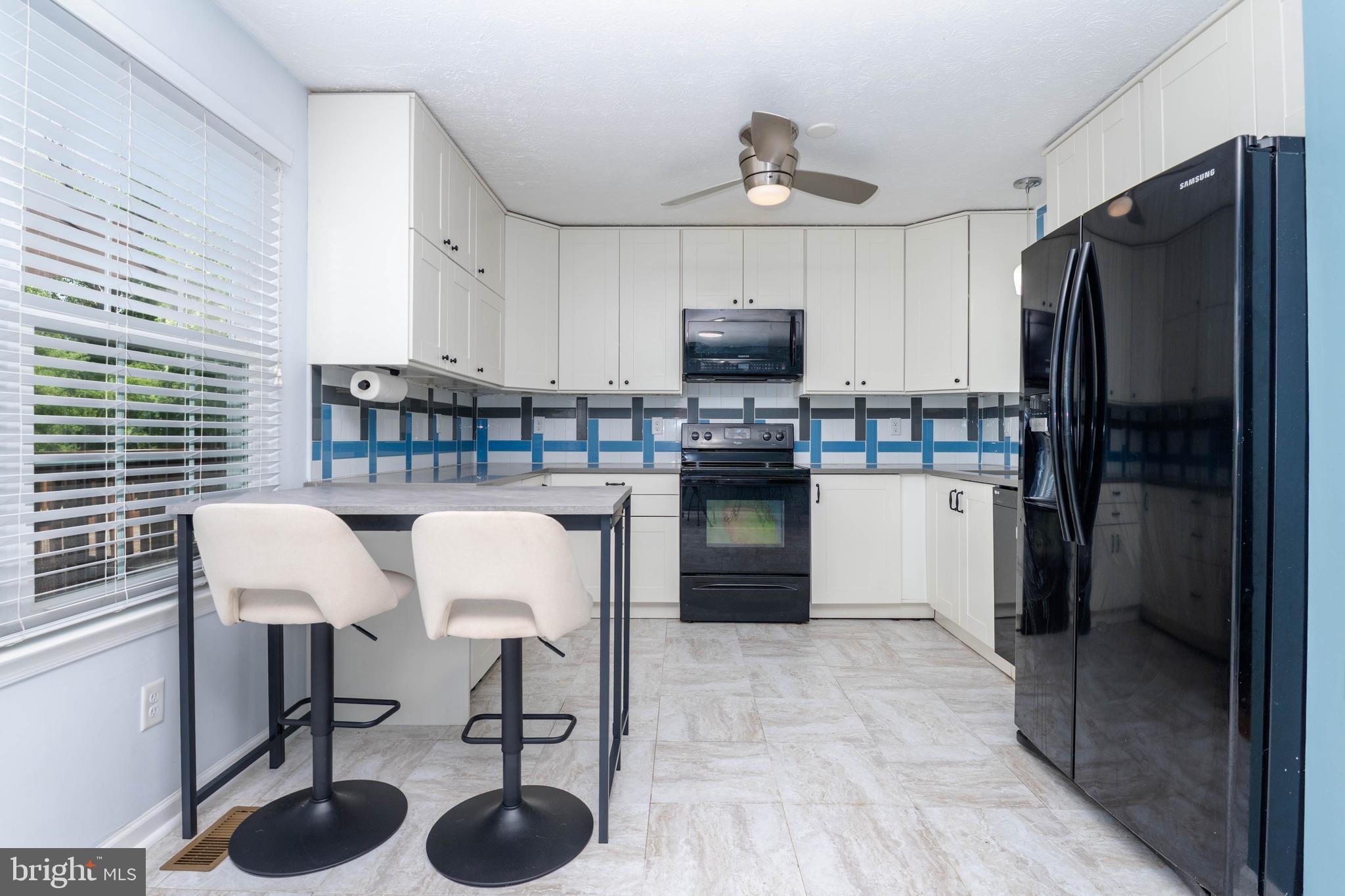 540 Doefield Court Abingdon, MD 21009 - Photo 14 of 48 a kitchen with stainless steel appliances a table chairs refrigerator and microwave
