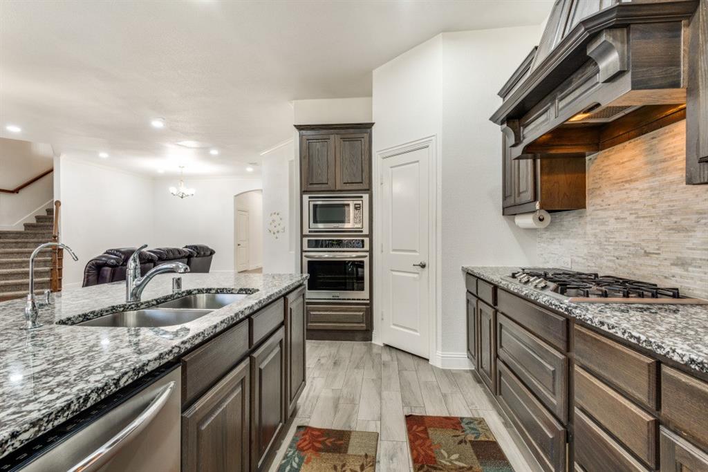 10312 Georgetown Place McKinney, TX 75071 - Photo 11 of 25 a kitchen with granite countertop a sink stainless steel appliances and counter space