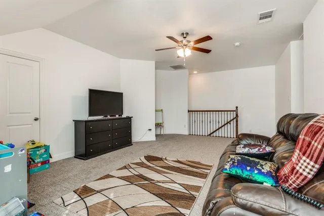 a view of a livingroom with furniture and a ceiling fan