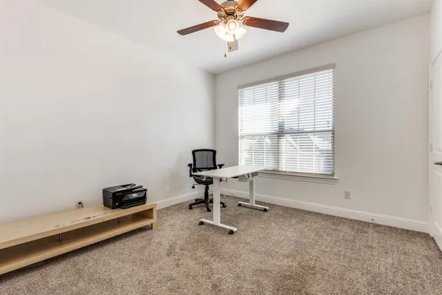 an empty room with a window and a fan