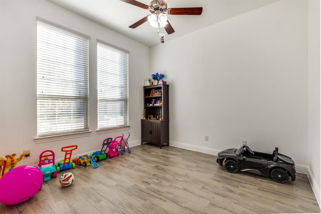 10312 Georgetown Place McKinney, TX 75071 - Photo 20 of 25 a bedroom with a bed and a chandelier